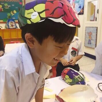 After school enrichment programs give students with the hands-on learning experiences they need to play, grow, and explore outside of the classroom. A kid wears a brain model hat built in Little Doctor School.