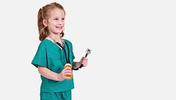Little girl dressed in scrubs holding a stethescope and pill bottle
